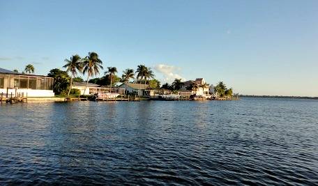 Cape Coral waterfront with boats and palm trees